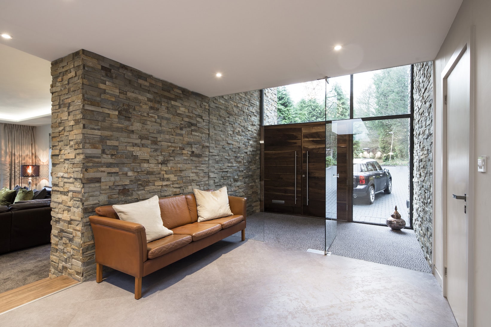 Norstone Ochre Slimline Stone Veneer on a large feature wall in a residential foyer with a floor to ceiling glass vestibule
